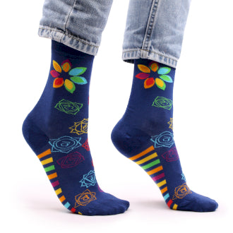 A pair of navy blue socks with colourful chakra patterns, worn on someone's feet.