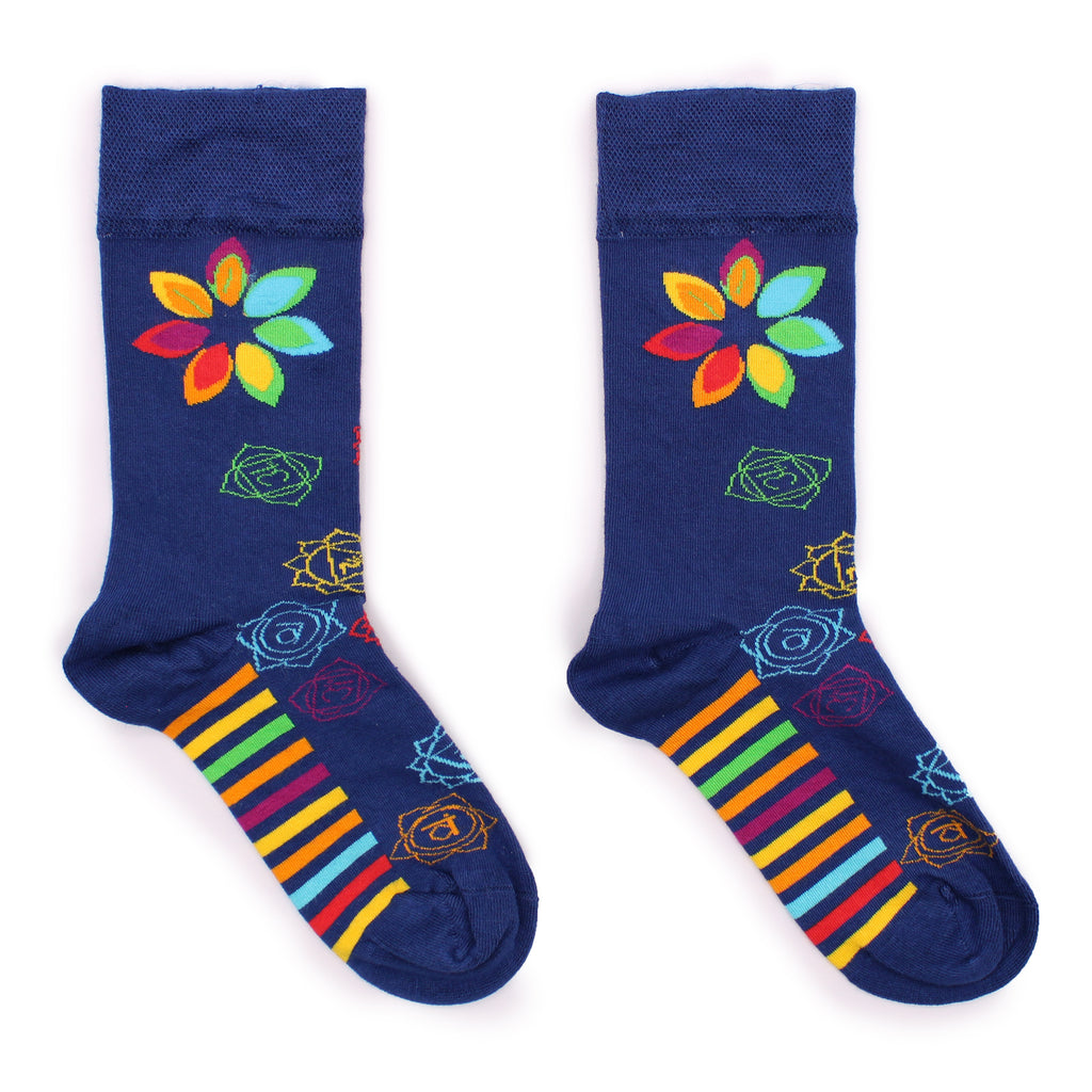 A pair of navy blue socks with colourful chakra patterns, laid on a white surface 