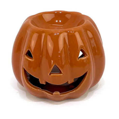 Ceramic jack-o'-lantern oil burner with a smiling face on a white background