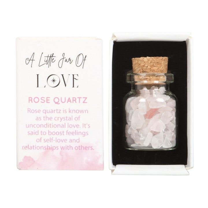 A white matchbox-style gift box labelled 'A Little Jar of Love' with a small glass jar filled with rose quartz crystal chips inside.
