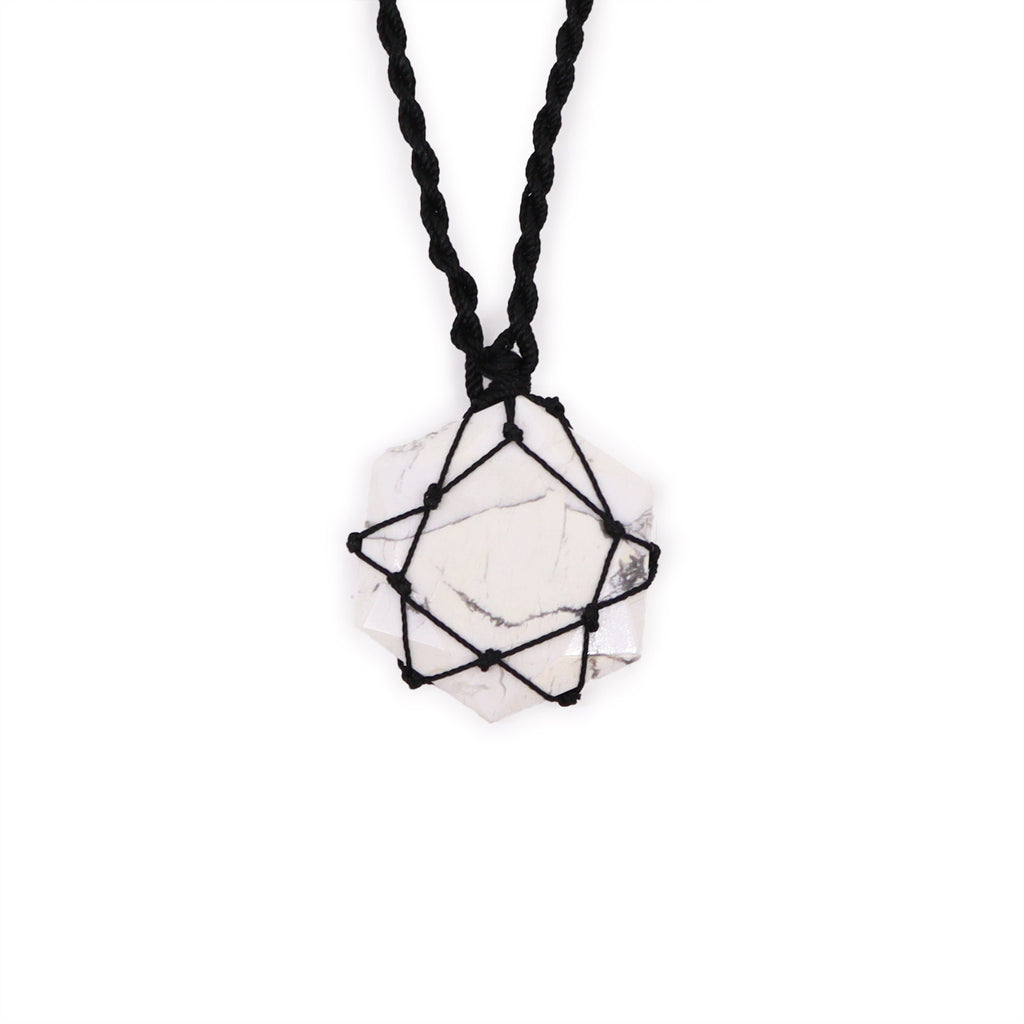 A hexagon pendant with a White Howlite gemstone, laced into a black necklace with an adjustable string, displayed against a white background