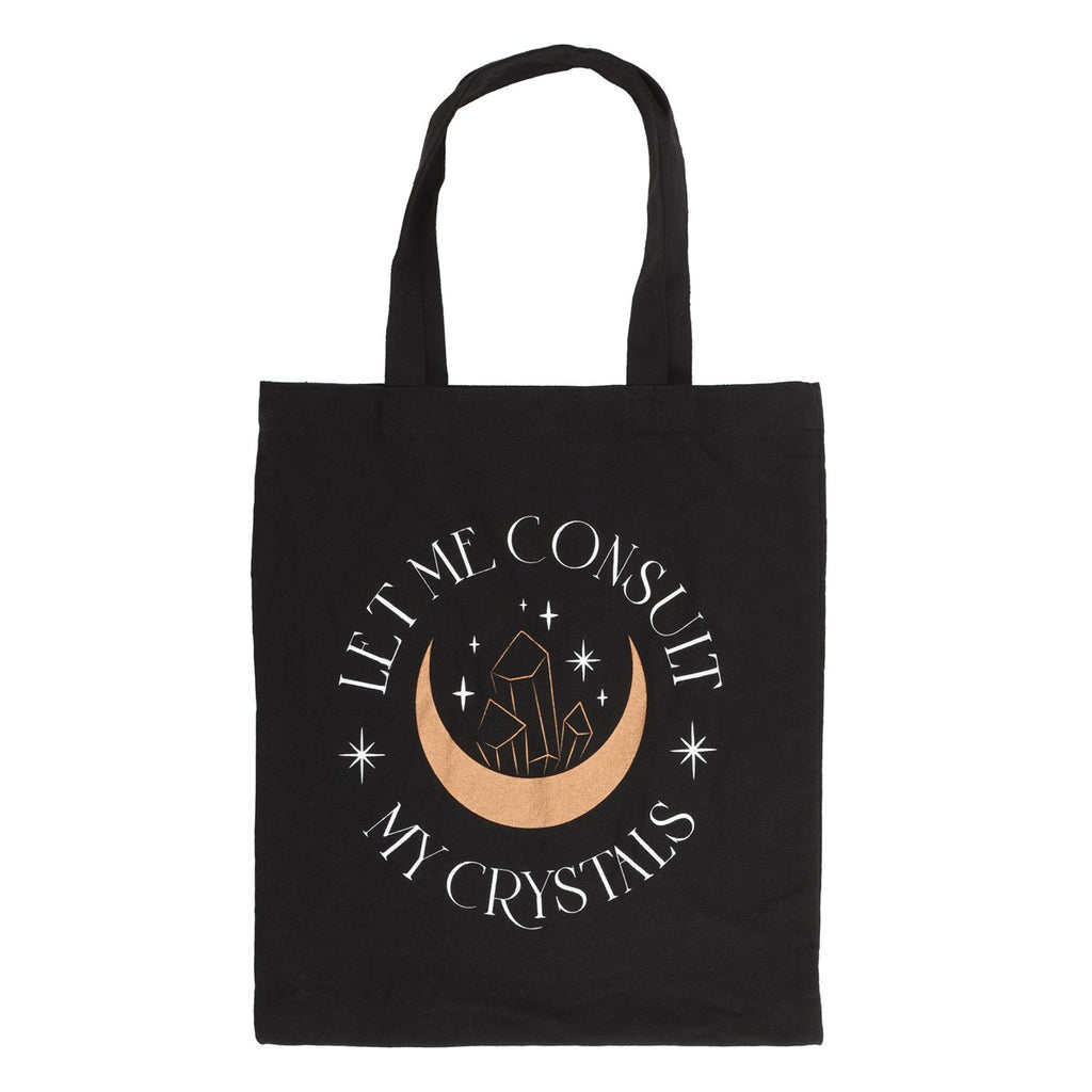 A black tote bag with crescent moon and crystal design which reads "Let me consult my crystals" on a white background.