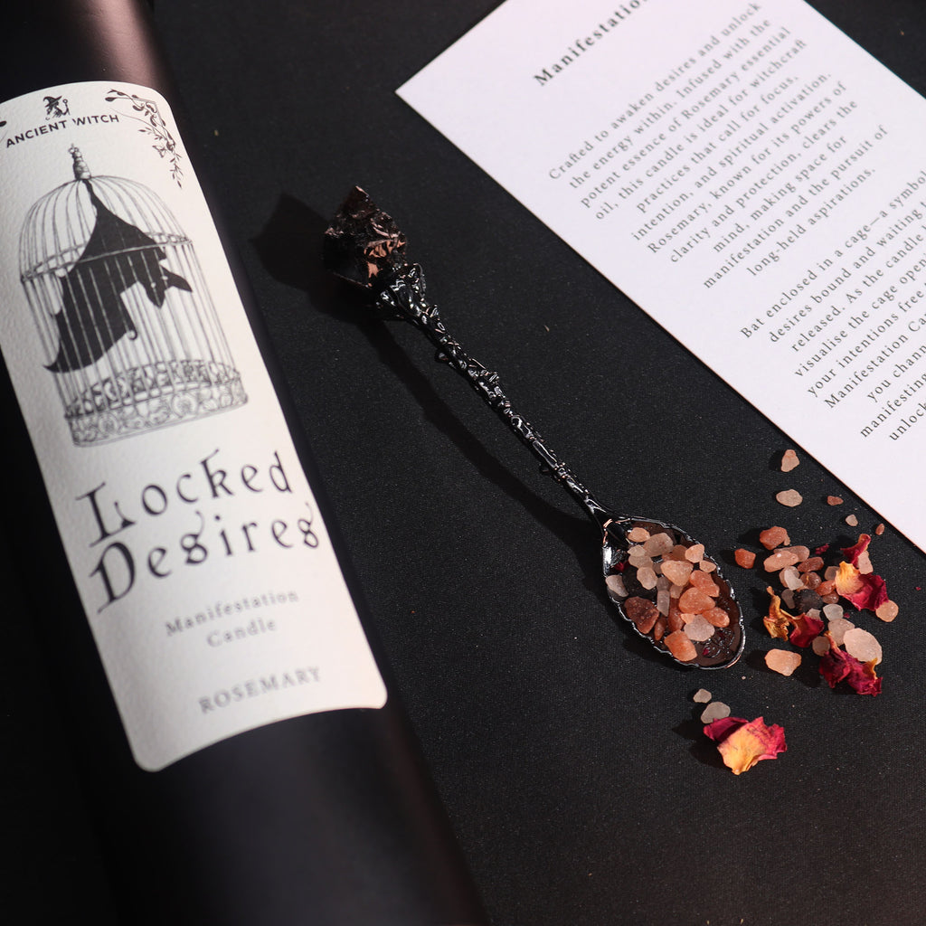 Locked Desires black candle with a witchy spoon and salts and rose petals on a black background