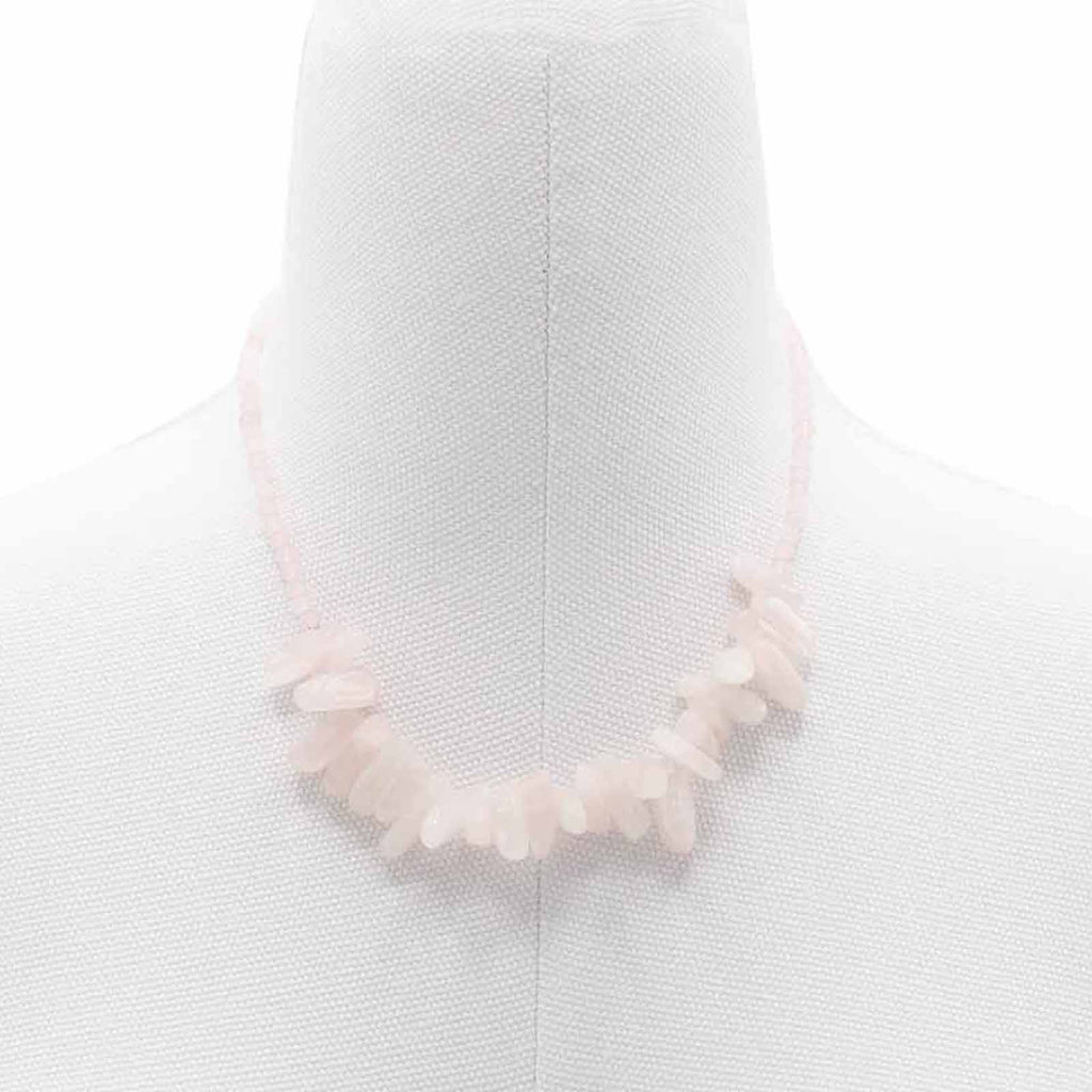 A light pink longstone rose quartz necklace displayed on a mannequin bust.