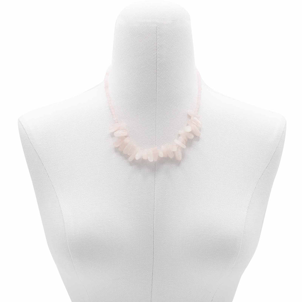 A pink longstone rose quartz necklace displayed on a mannequin bust.