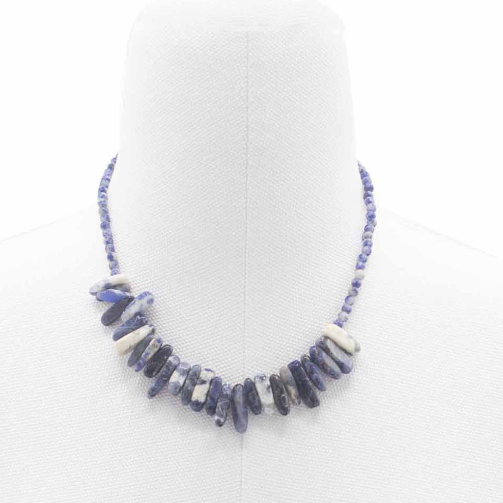 A blue longstone Sodalite necklace displayed on a white mannequin. 