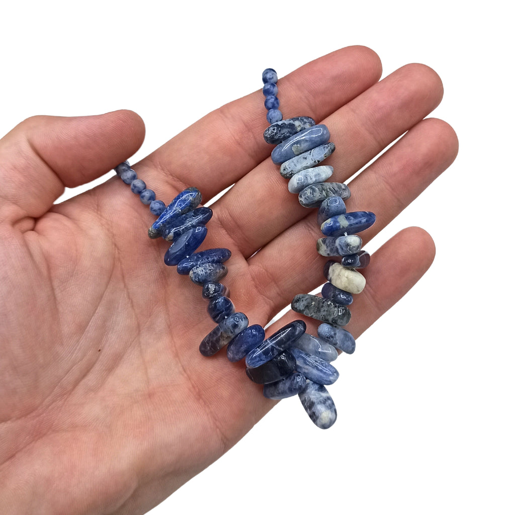A bleu longstone Sodalite necklace held in a hand.
