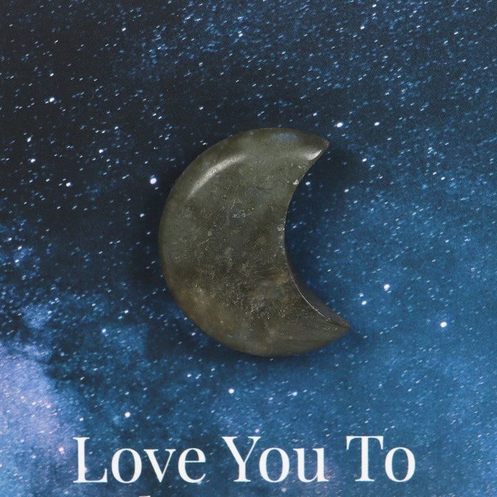 A close up of a blue night sky themed card which says "Love you to" with a Labradorite crescent moon stuck above it.