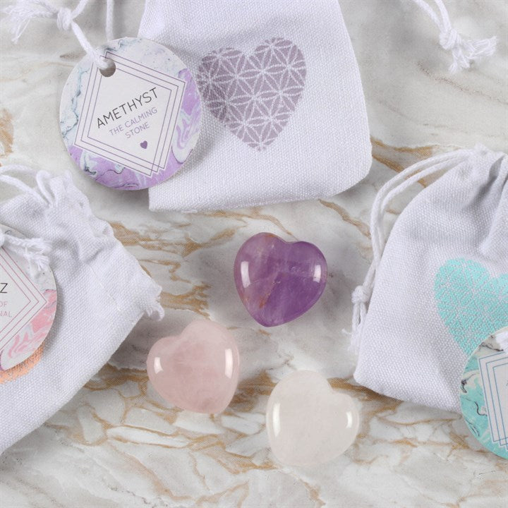 Three crystal hearts; amethyst; rose quartz and clear quartz with little matching bags.
