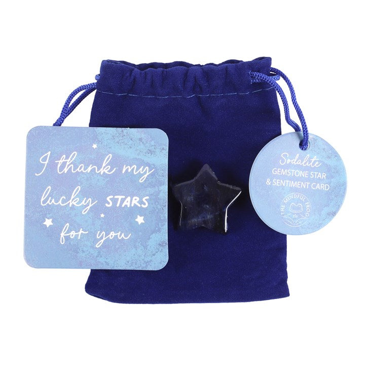 A blue square card which reads "I thank my lucky stars for you" next to a blue crystal star which lays on a blue bag