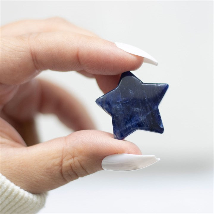 A hand holds a blue crystal star