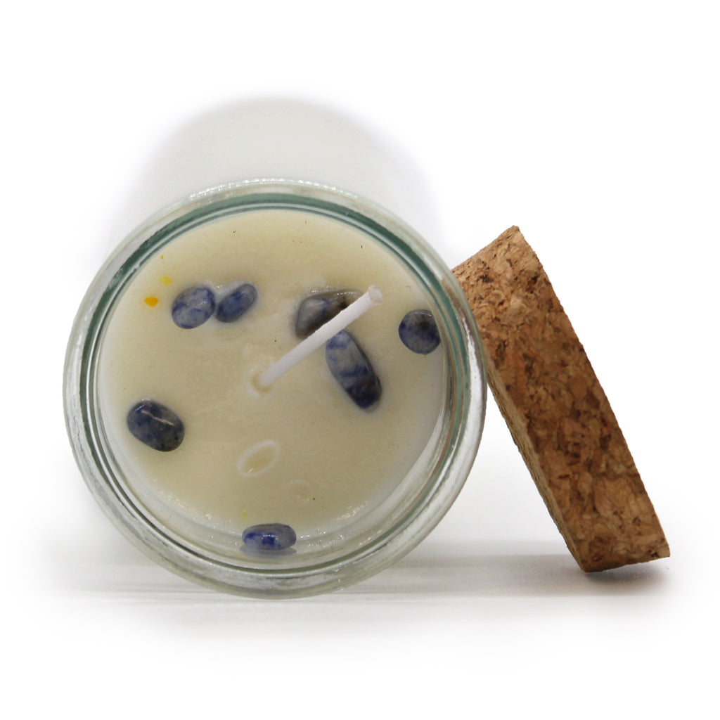 A top view of a Magic Spell Candle with embedded gemstones next to its cork stopper