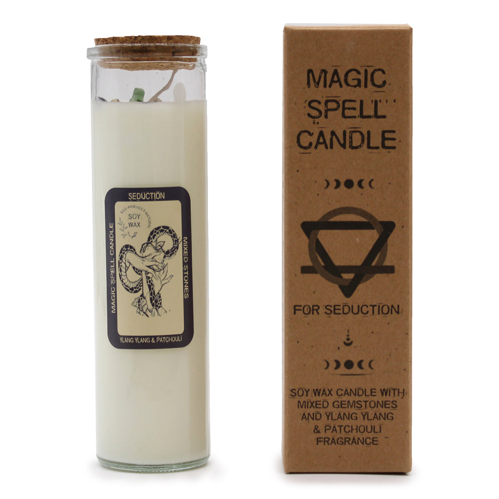A "Seduction" Magic Spell Candle with embedded gemstones. The candles are made of soy wax and have glass containers with cork stoppers. It is next to its brown packaging.