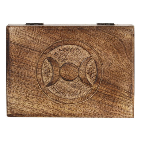A wooden mango tarot box viewed from above with an engraved triple moon design in the middle with a white background