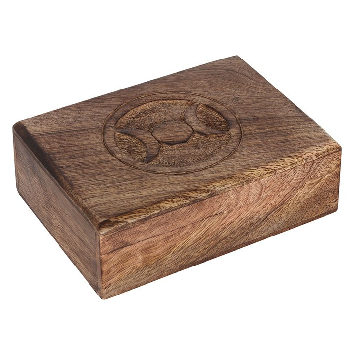A wooden mango tarot box viewed from above and to the side, with an engraved triple moon design in the middle with a white background