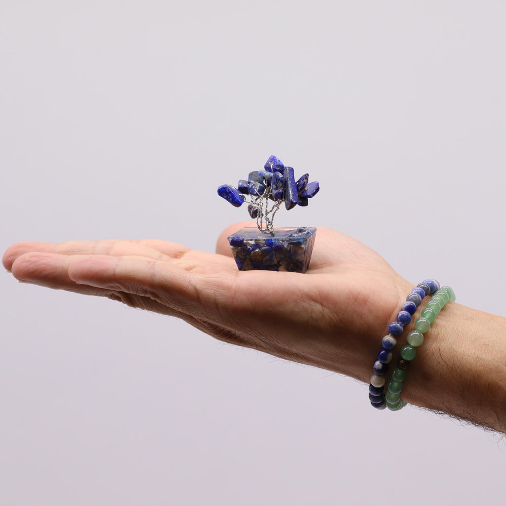 A mini sodalite tree on an orgonite base, held in an open hand