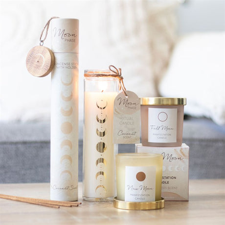 A coconut scented, tube shaped candle with moon phase designs, displayed alongside other candles in containers.