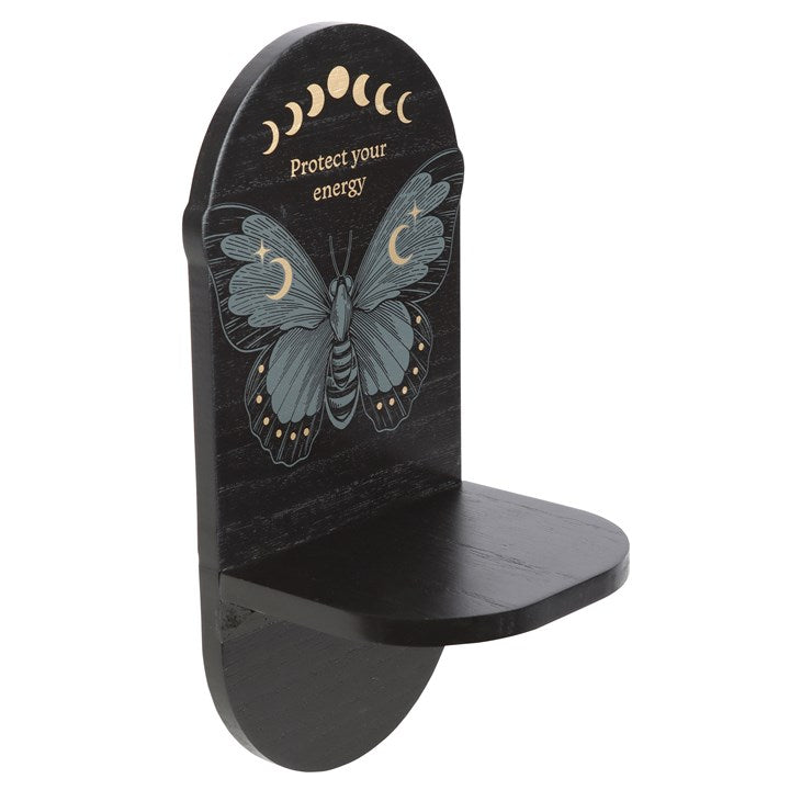 A black wooden altar shelf with a moth design and text 'PROTECT YOUR ENERGY' on it from the side.