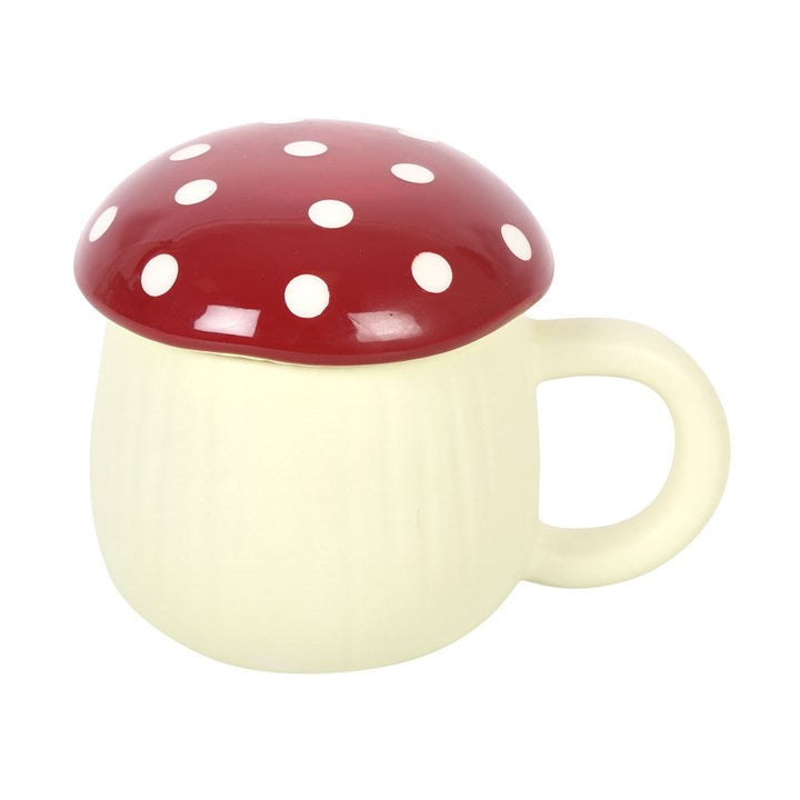 A white ceramic mug with a red mushroom-shaped lid and dots pattern on the lid against a white background.