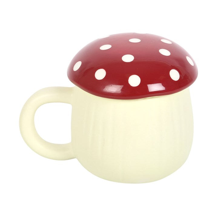 A white ceramic mug with a red mushroom-shaped lid and dots pattern on the lid.