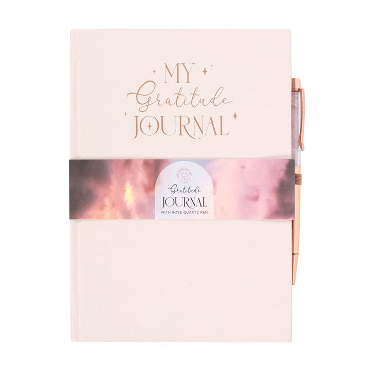 A light pink journal with "My Gratitude Journal" written on the front. A pen is attached to the side.