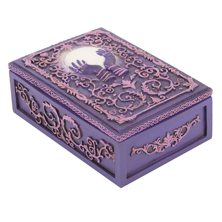 A pink and purple resin storage box with a mystical hand and crystal ball design, featuring raised filigree details.