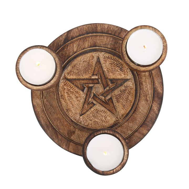 A round wooden tea light holder with an engraved pentagram design with space for three tea lights. Sits against a white background