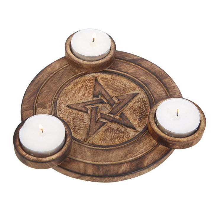 A round wooden tea light holder with an engraved pentagram design with space for three tea lights. Sits against a white background