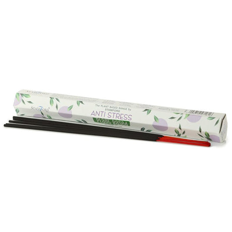 A white tube of "Anti Stress" incense sticks next to dark and red coloured incense sticks. 