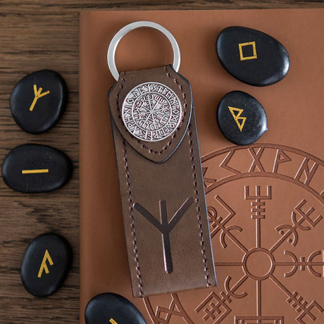 Faux leather keychain with Viking Runes design on a brown leather surface with stones featuring runes.