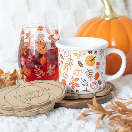 A set of wooden coasters with a pumpkin shape, displayed alongside a pumpkin and autumn-themed mug.