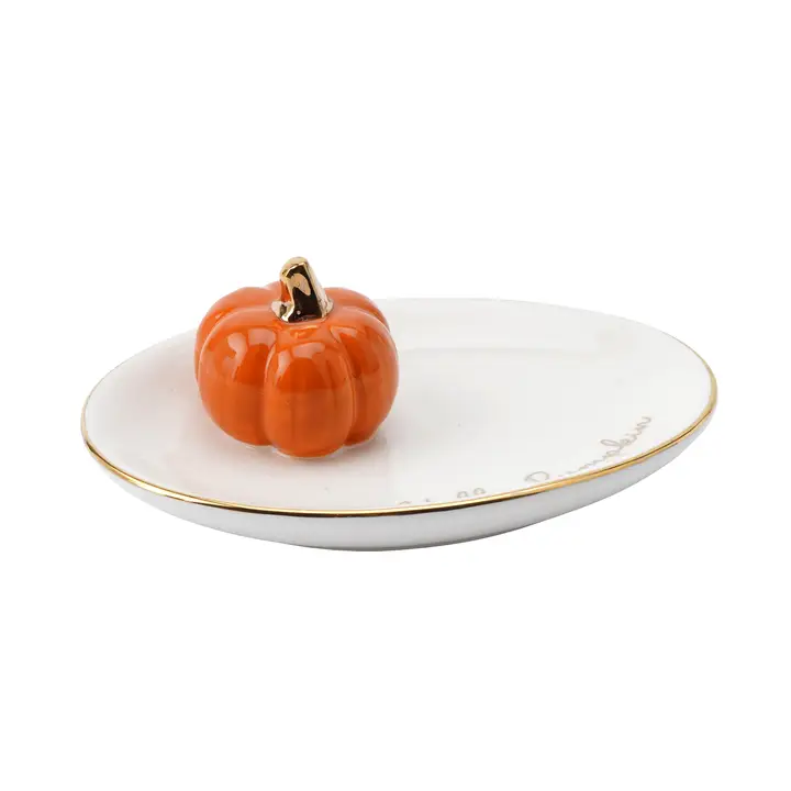 Pumpkin-shaped trinket dish on a white plate with gold rim
