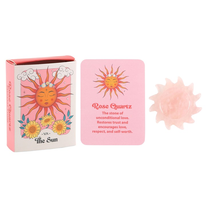 A carved Rose Quartz crystal sun alongside its packaging, which includes a card with the text 'Rose Quartz' and 'The Sun' indicating a tarot card-inspired design.
