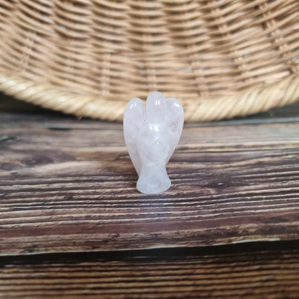 A pink crystal angel on a wooden backdrop 