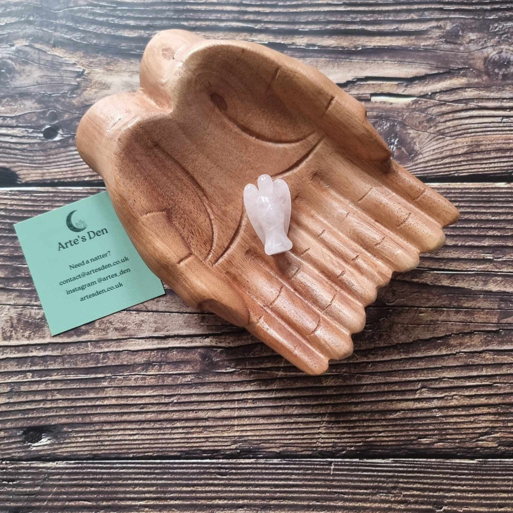 A pink crystal angel on a wooden backdrop 