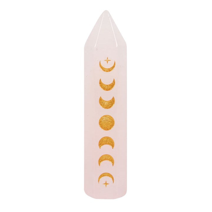 A Rose Quartz crystal point with gold-tone moon phase engraving against a white background.