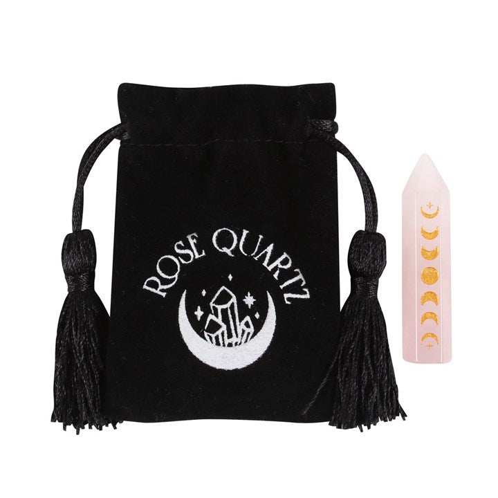 A Rose Quartz crystal point with gold-tone moon phase engraving, is next to a black velvet bag which says "Rose Quartz"