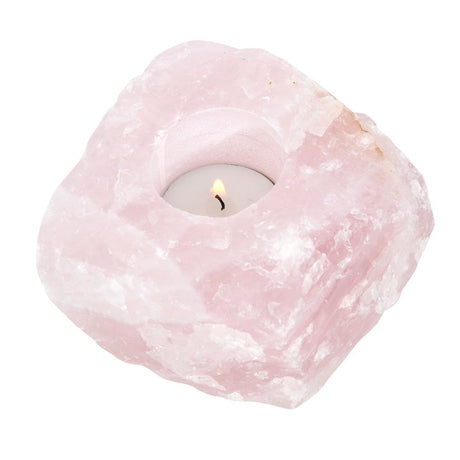 A rough pink rose quartz tealight holder with lit candle