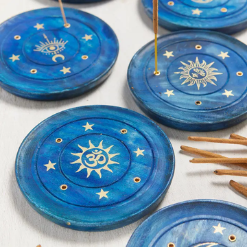 Blue incense holders with celestial designs on a white surface