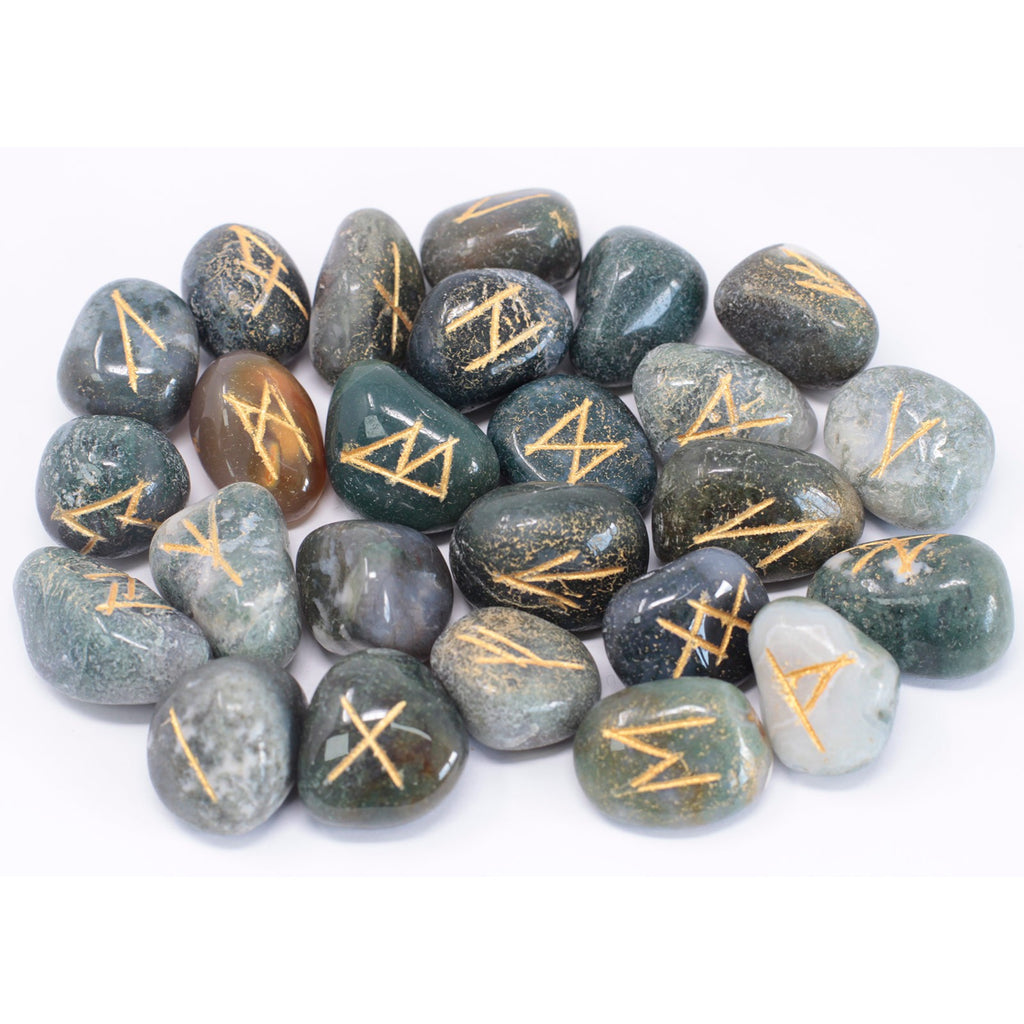 A close up of a collection of Moss Agate rune stones on a white surface