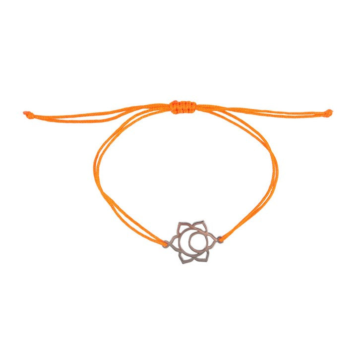 A Sacral Chakra charm bracelet with an orange band and a silver charm against a white background 