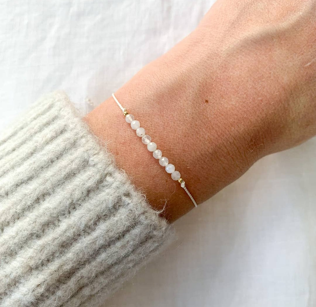 A Moonstone silk bracelet with beads approximately 3mm in size, displayed on a wrist