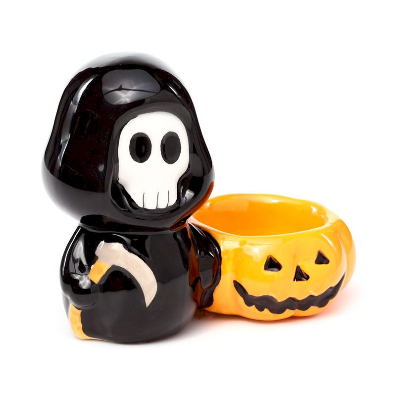 Black skeleton figure with a yellow jack-o'-lantern tea light holder on a white background