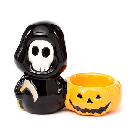 Black skeleton figure with a yellow jack-o'-lantern tea light holder on a white background