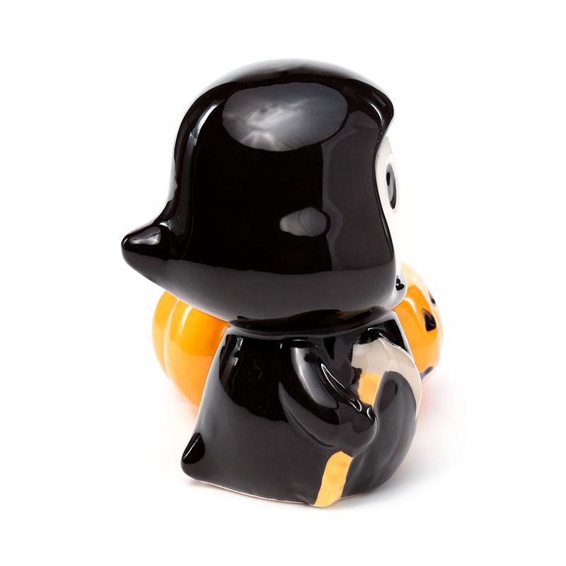 Black skeleton figure with a yellow jack-o'-lantern tea light holder from the side on a white background