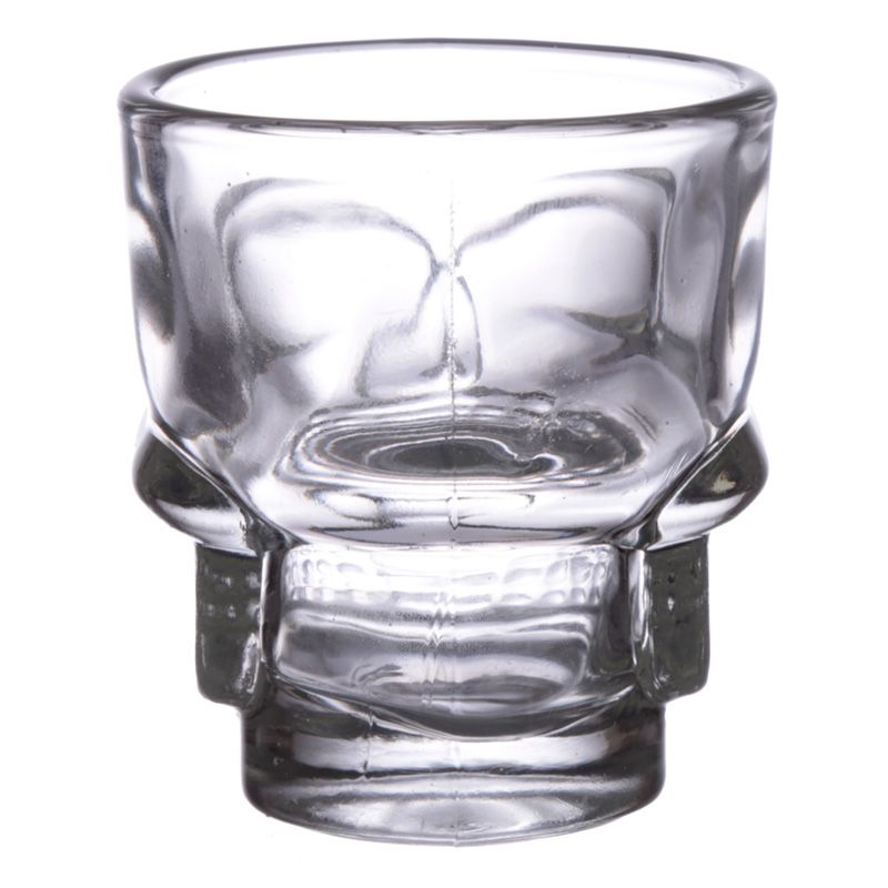 A skull themed shot glass on a white background from behind