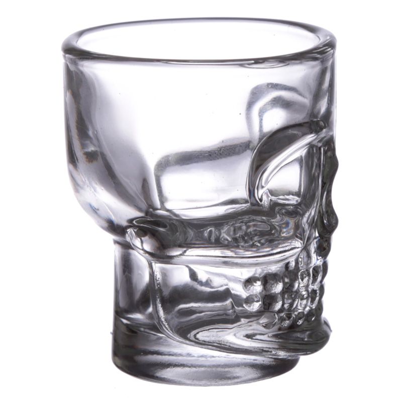 A skull themed shot glass from the side on a white background