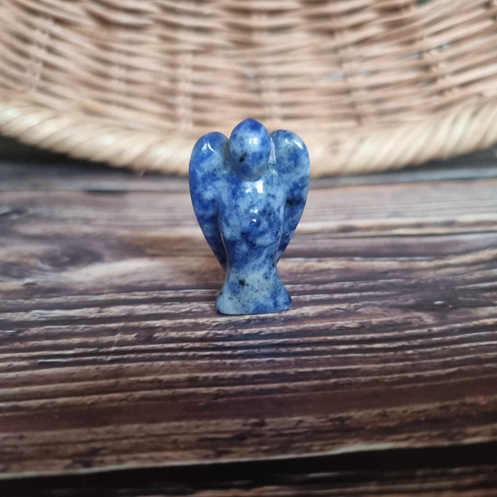 A blue crystal angel on a wooden backdrop 
