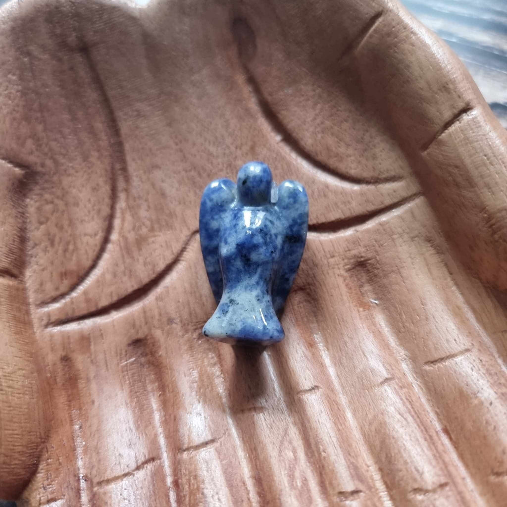 A blue crystal angel on a wooden backdrop 