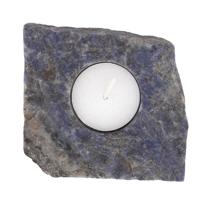 A rough blue sodalite tealight holder with lit candle
